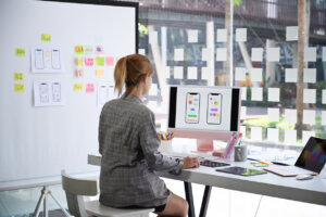 UX designer planning phone app development template layout wireframe design at modern office.