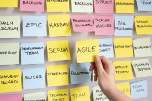 hand picks out Agile from a sticky note