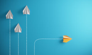 paper airplanes moving in same direction but one moves in a different direction