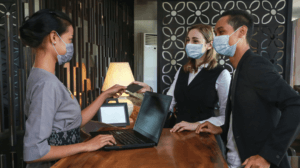 service design hotel check-in during covid, staff and guests wear masks