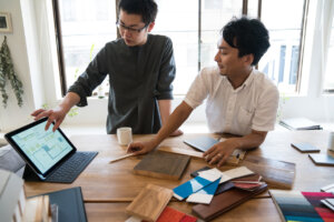 Two interior designers brainstorming around a digital tablet