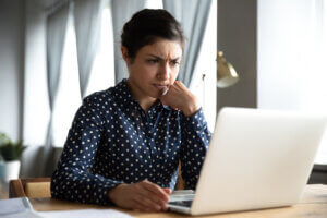 Concerned indian woman look at laptop frustrated about computer problem