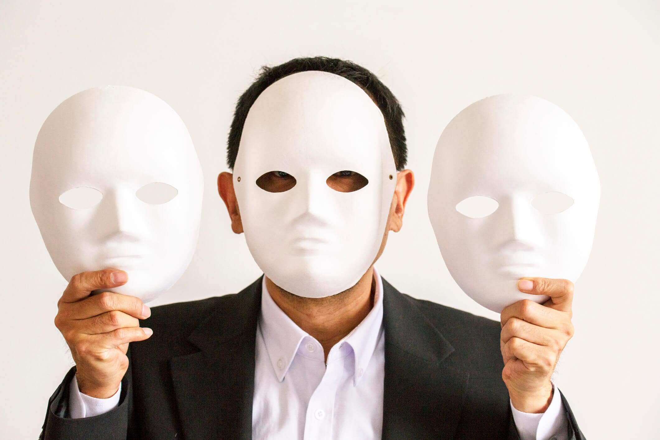 man wearing and holding masks