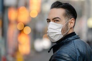 Man covering his face with pollution mask for protection from viruses