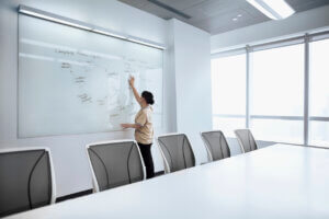 woman at a white board in an empty room