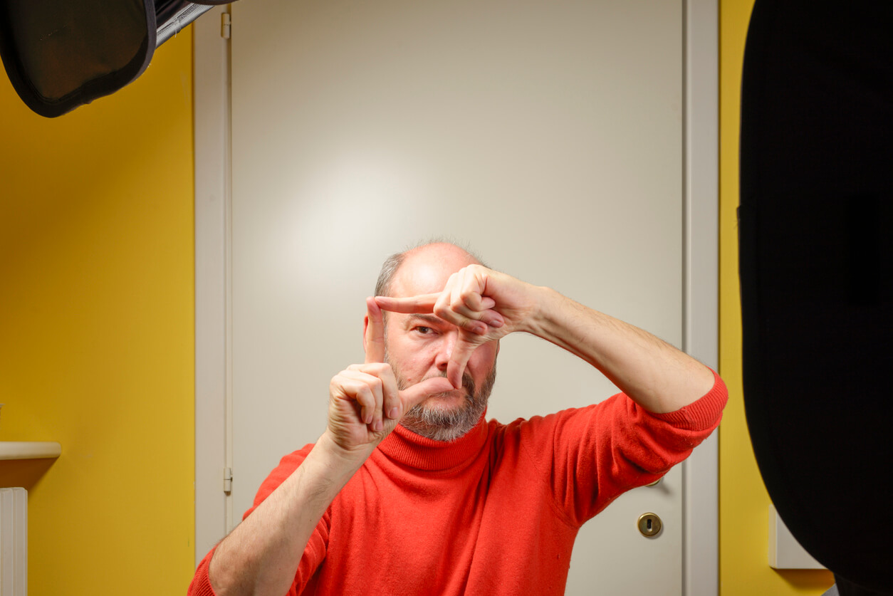 Man framing an image in lockdown at improvised home studio