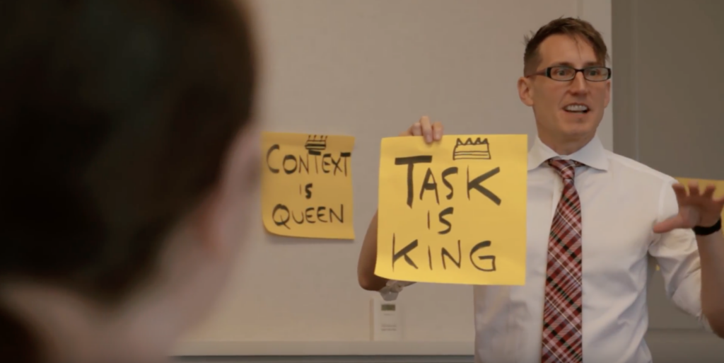 Frank Spillers holds up Task is King sign in a UX training
