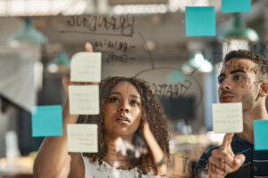 UX as a team sport two designers discuss a UX strategy over sticky notes