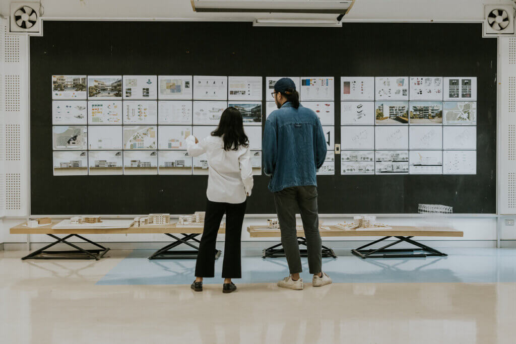 UX organizational transformation image with two employees viewing a huge wall of designs