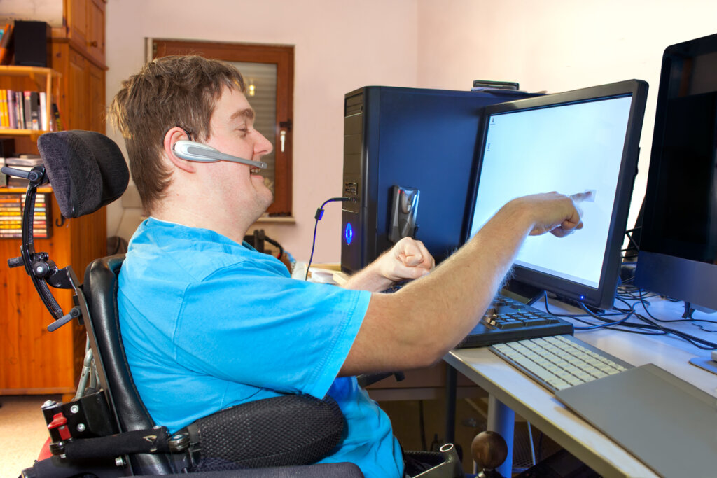wheelchair user points at a screen during an accessibility test