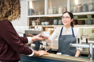 asian barista serves customer example of service design
