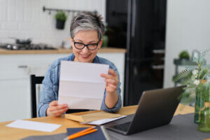 woman with glasses looks at paper