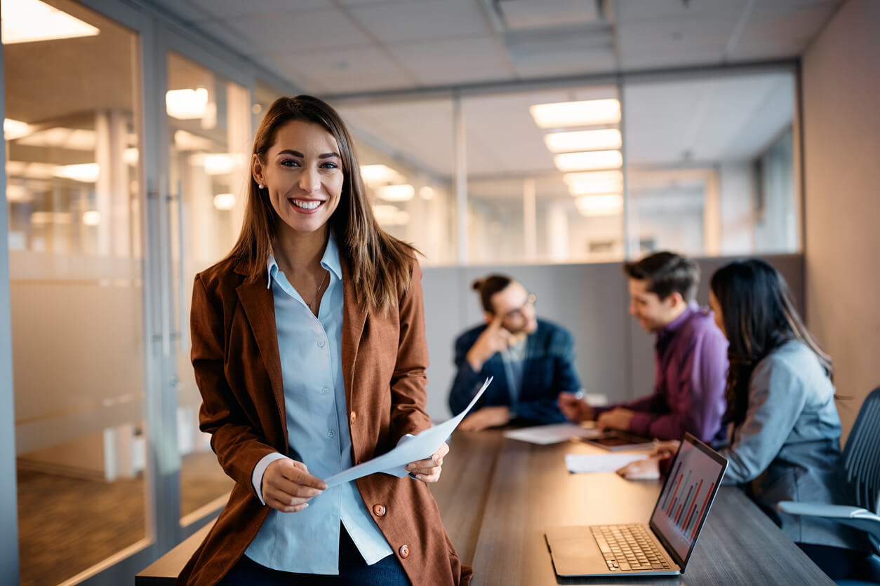 product manager smiles as her team meets behind her