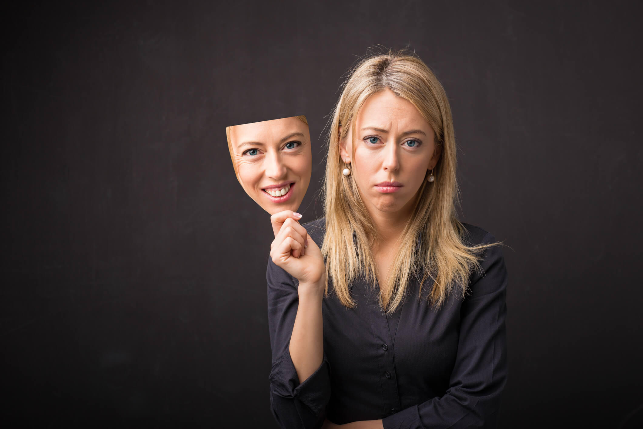 Woman holding persona mask of her happy face