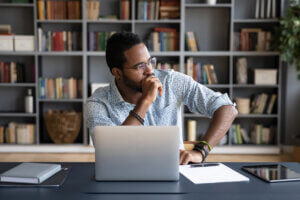 Black man answers UX survey, looking away in deep thought