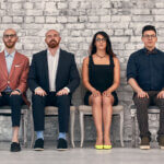 four team members sit side by side in a row