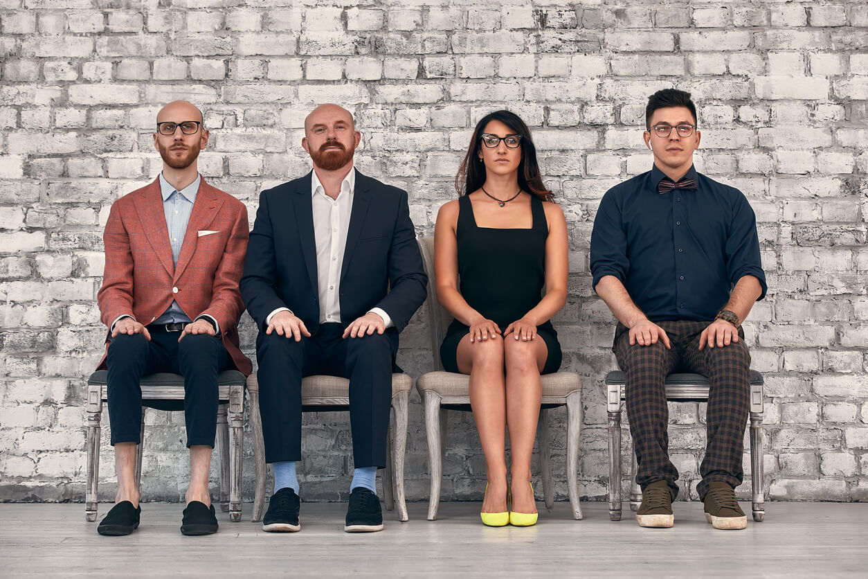 four team members sit side by side in a row