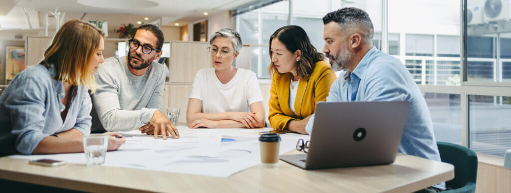 Multicultural designers sharing creative ideas during a meeting in a modern office. Group of innovative businesspeople having a discussion while working on a new project.