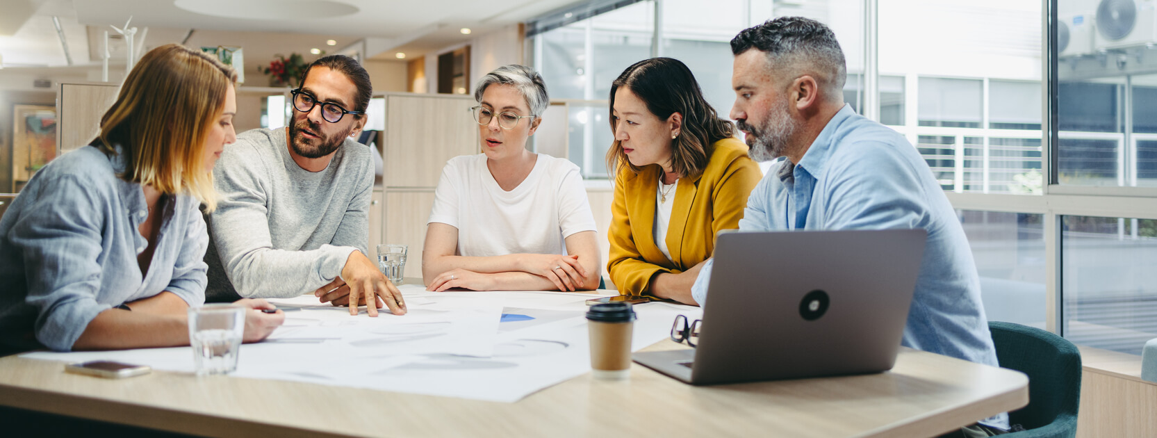 Multicultural designers sharing creative ideas during a meeting in a modern office. Group of innovative businesspeople having a discussion while working on a new project.