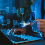 org chart map floating above a laptop with human hands on the keyboard and gesturing to the visualization