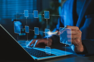 org chart map floating above a laptop with human hands on the keyboard and gesturing to the visualization