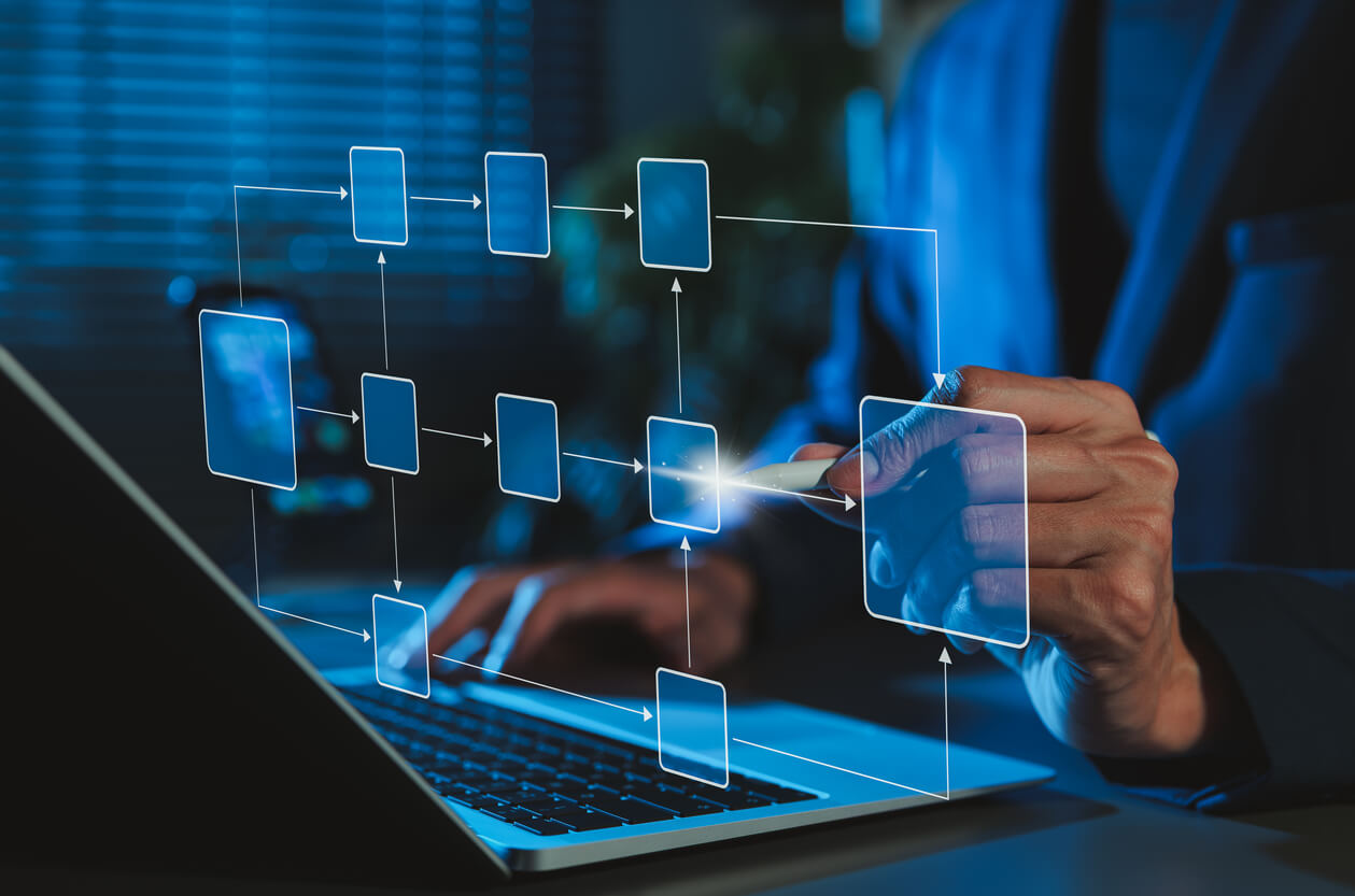 org chart map floating above a laptop with human hands on the keyboard and gesturing to the visualization